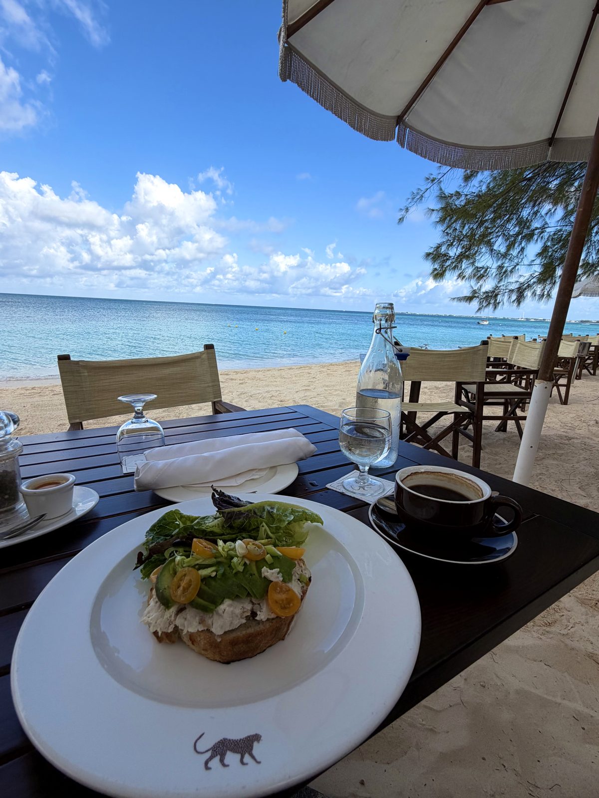 Avocado toast and coffee on a table by the beach