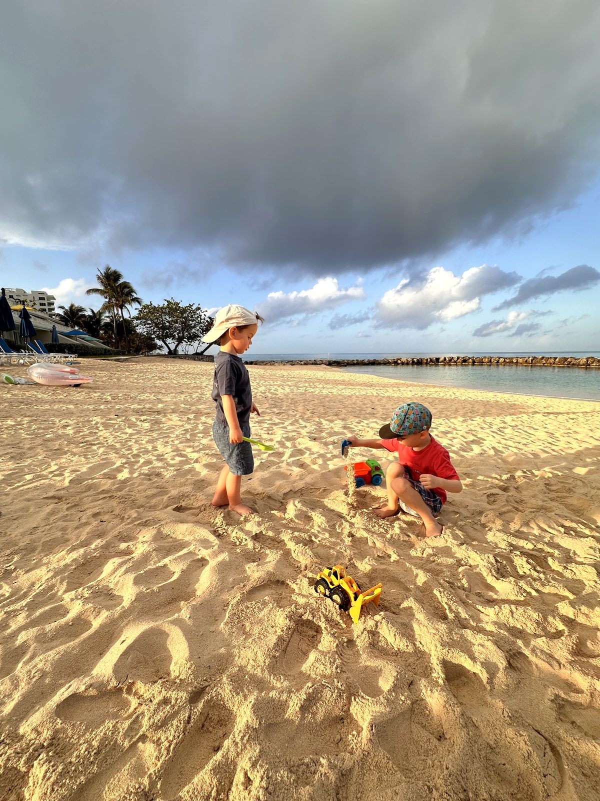 Two kids digging in the sand at Sunset Cove