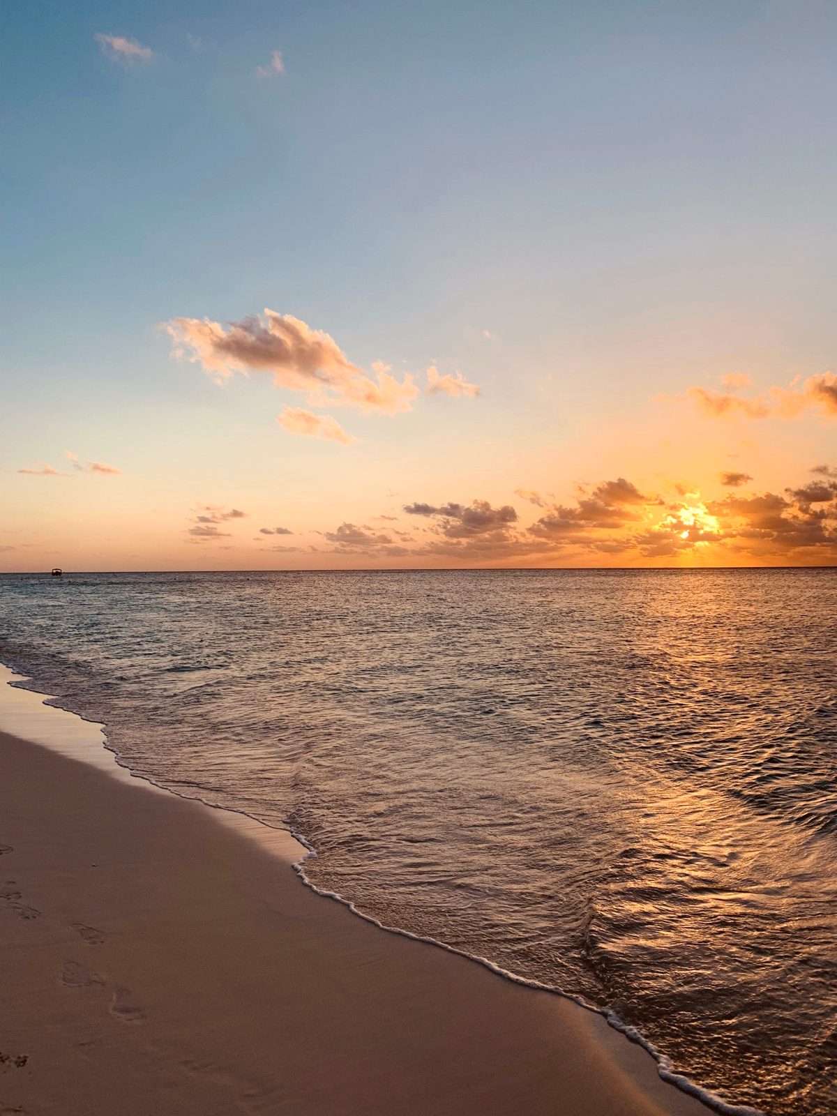 The sun setting over calm water from Seven Mile Beach