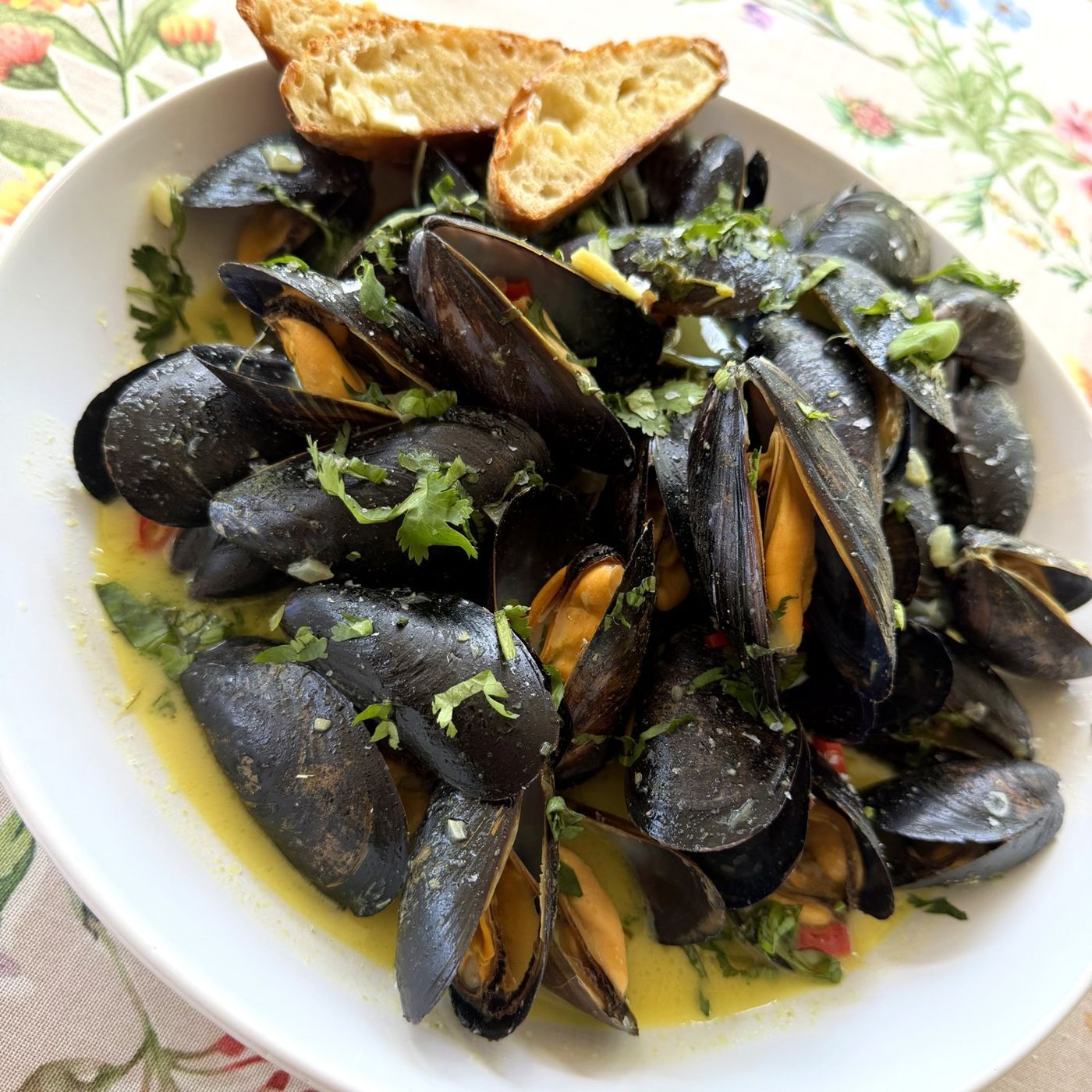 A pot of mussels in green curry coconut broth