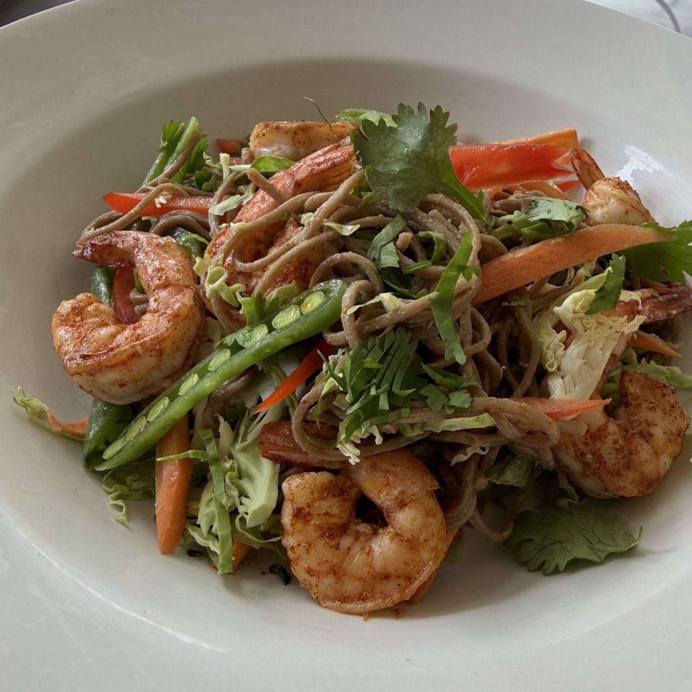 Cold peanut soba noodle salad with julienned vegetables and seared shrimp