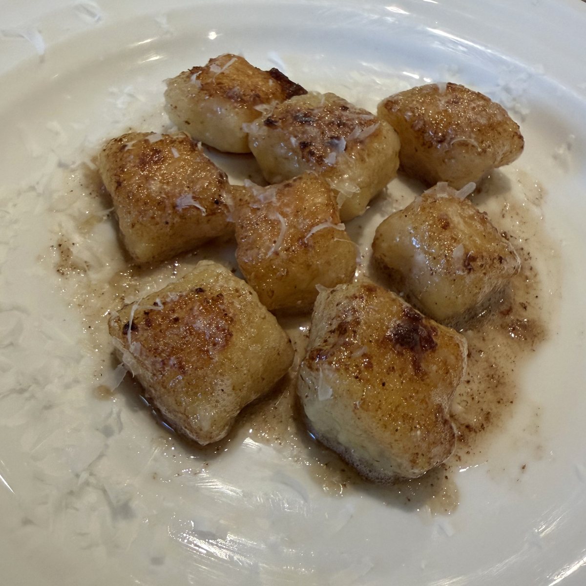 Potato gnocchi seared golden in brown butter, on a white plate