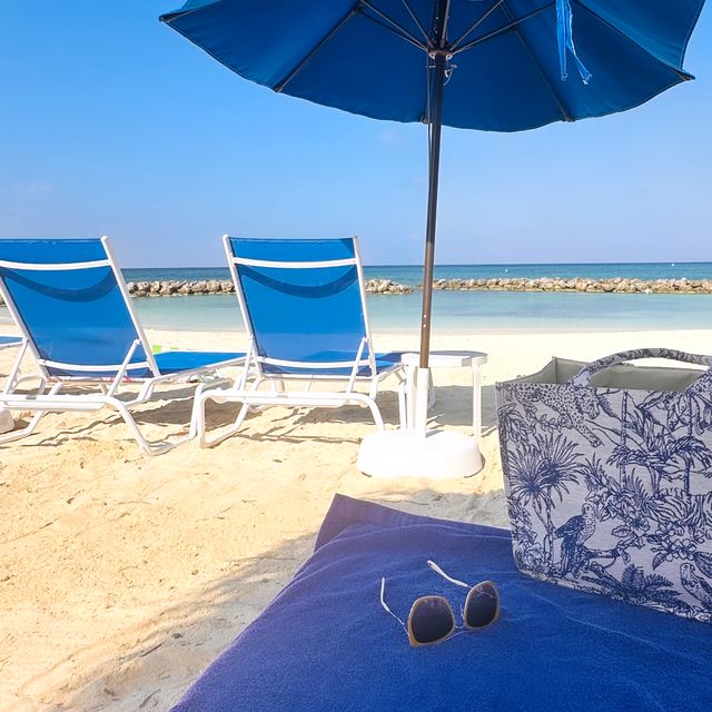 A blue umbrella and loungers at Sunset Cove, Grand Cayman