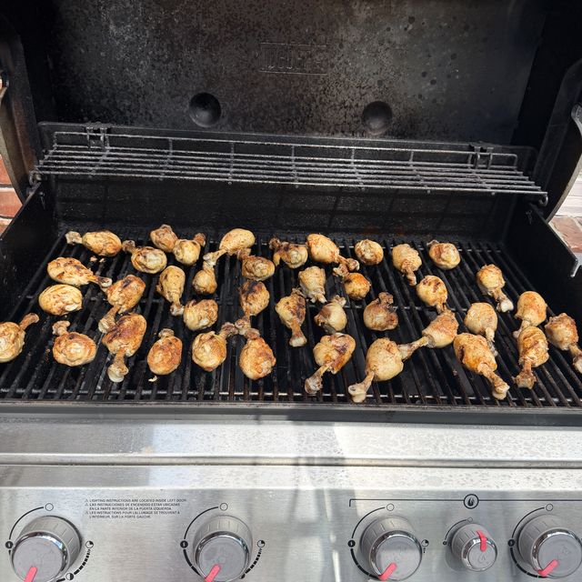 Rows of drumsticks browning on a gas barbecue