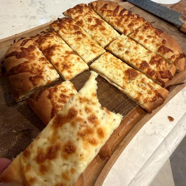 Garlic fingers cut into strips on a wooden board